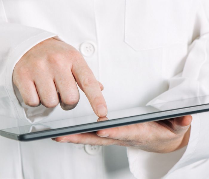 Female general medical practitioner using tablet computer in hospital office